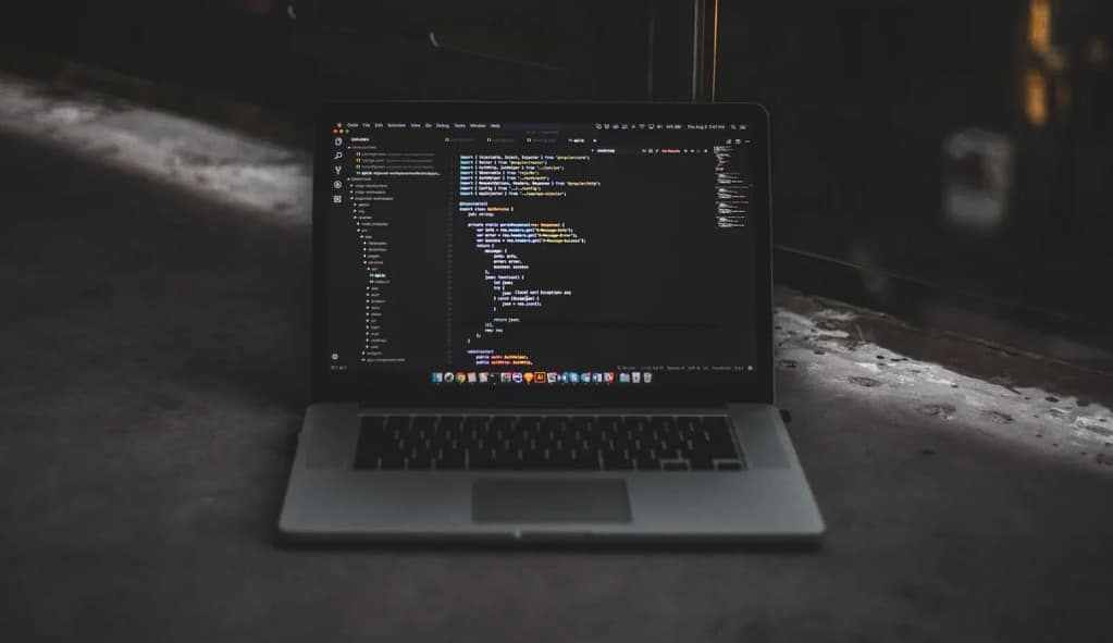 A laptop running code on a floor